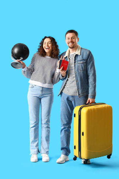 Молодая пара с паспортами, глобусом и чемоданом на синем фоне - Фото, изображение