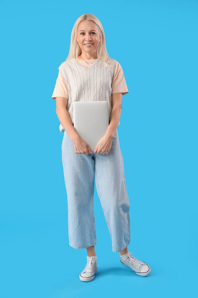 Dojrzałe kobieta programista z laptopem na niebieskim tle - Zdjęcie, obraz