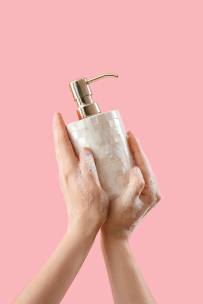 Kädet nestemäisellä saippualla vaaleanpunaisella taustalla - Valokuva, kuva
