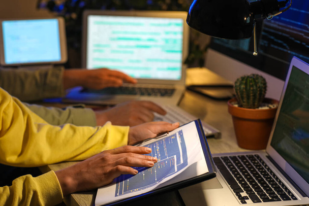 Γυναίκα προγραμματίστρια που εργάζεται στο γραφείο τη νύχτα, κοντινό πλάνο - Φωτογραφία, εικόνα