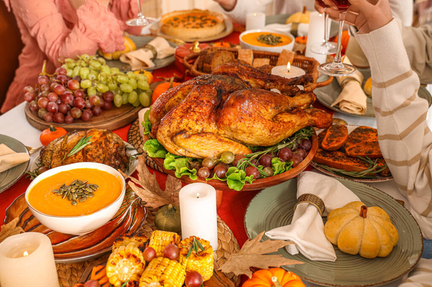 Groep jonge vrienden dineren aan feestelijke tafel op Thanksgiving Day, close-up - Foto, afbeelding