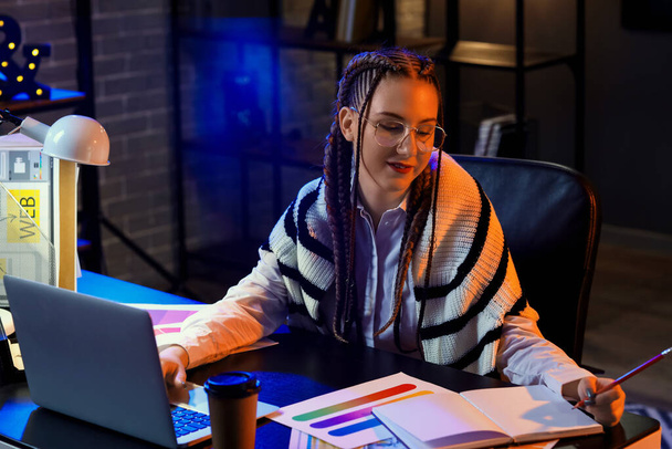 Nainen suunnittelija työskentelee kannettavan tietokoneen toimistossa yöllä - Valokuva, kuva