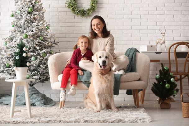 Щаслива молода мати і її маленька дочка з милою собакою Лабрадором вдома напередодні Різдва - Фото, зображення