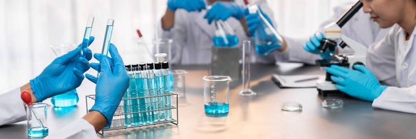 Groep van toegewijde wetenschappers voert chemische experimenten en onderzoek in het medisch lab als baanbrekende ontwikkeling voor vaccins of antibiotica. Farmaceutisch en biochemisch laboratorium. Neoterisch - Foto, afbeelding