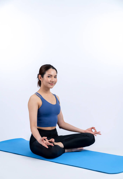 Aasialainen nainen urheiluvaatteet tekemässä jooga liikuntaa kunto matto hänen harjoitus rutiini. Terve kehonhoito ja rauhallinen meditaatio jooga elämäntapa koko kehon ammuttu eristetty tausta. Voimakas - Valokuva, kuva