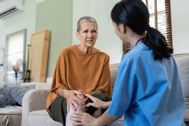 Oudere vrouwen hebben kniepijn van artrose en laten hun symptomen onderzoeken door een arts voor fysiotherapie. - Foto, afbeelding