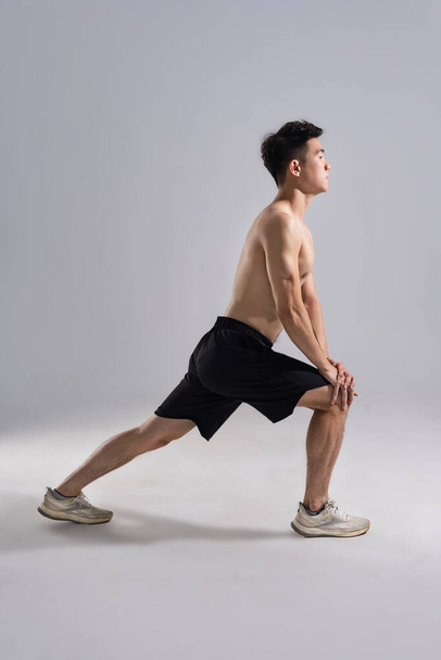 Afbeelding van Aziatische mannelijke atleet met een goede lichaamsbouw op witte achtergrond - Foto, afbeelding