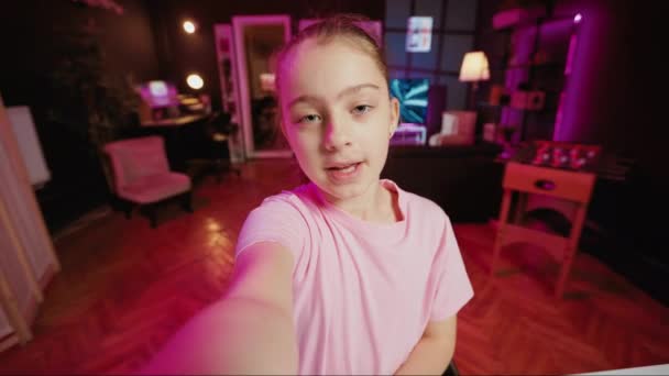 Gen z youngster filming POV style video with phone for online channel, talking with viewers. Kid telling audience topics she wishes to explore in future clips, recording with selfie smartphone camera - Footage, Video