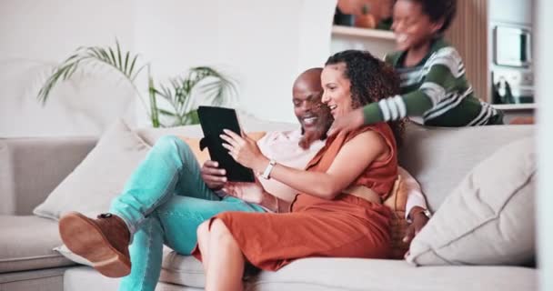 Χαρούμενη μαύρη οικογένεια, tablet και αγκαλιά χαλαρώστε στον καναπέ για δέσιμο, αγκαλιά ή αγάπη μαζί στο σπίτι. Αφρικανή μητέρα, πατέρας και παιδιά χαμογελούν στην τεχνολογία για τα μέσα κοινωνικής δικτύωσης ή για διασκέδαση στο σπίτι. - Πλάνα, βίντεο