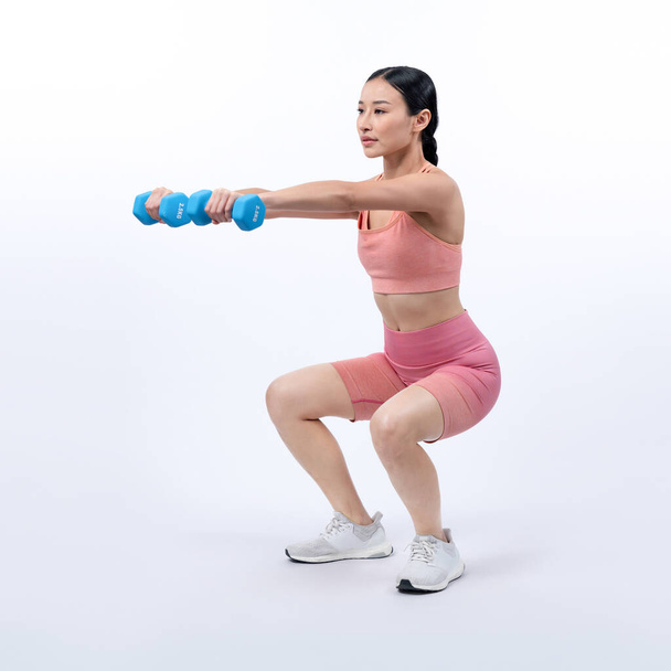 隔離された背景で運動を持ち上げるダンベル重量を行っている活発な女性. ボディワークアウトルーチンとしての若い運動アジアの女性の強さと耐久トレーニングセッション. - 写真・画像