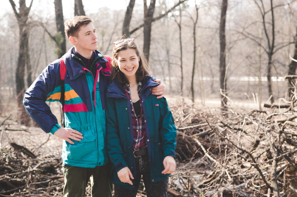 Young beautiful happy hipster couple brunette girl and guy having great fun time while travelling and walking in the woods forest - Foto, Imagem