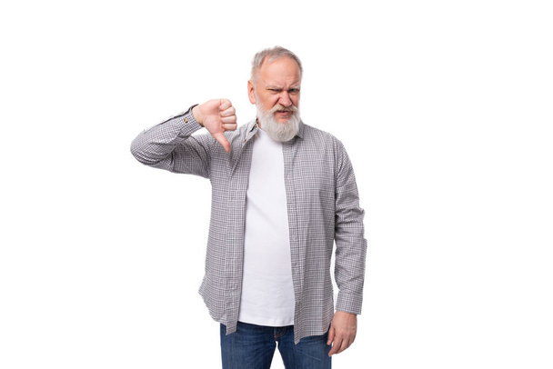 όμορφος γκριζομάλλης ηλικιωμένος άνδρας με πουκάμισο αμφιβάλλει για ένα λευκό φόντο με αντίγραφο χώρο. - Φωτογραφία, εικόνα