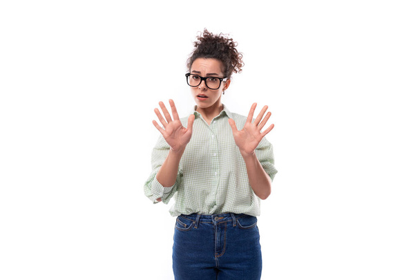 junge überraschte brünette Frau mit Brille zeigt ihre Hände auf weißem Hintergrund im Kopierraum. - Foto, Bild