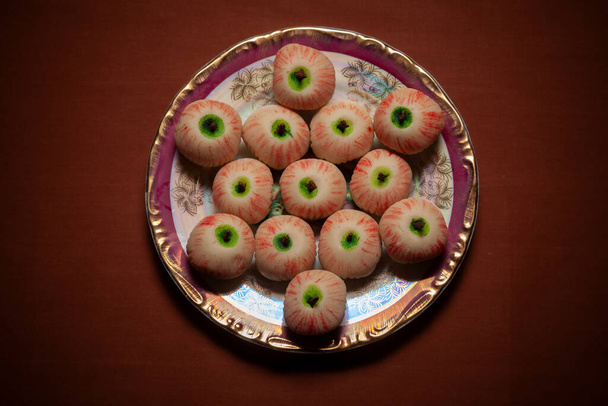 Top view egy indiai hagyományos édes nevű "khoya alma alakú Mithai" szolgált kerámia lemez. - Fotó, kép