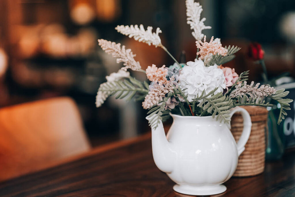 Στην ομορφιά προσθέτουν αποξηραμένα λουλούδια σε βάζα τοποθετημένα στα τραπέζια του εστιατορίου. ιδέες διακόσμησης σπιτιού. - Φωτογραφία, εικόνα