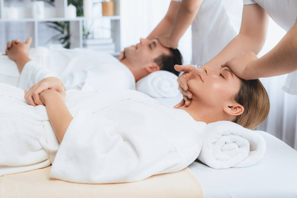 Kavkazský pár se těší relaxační antistresové masáži hlavy a hýčkání pleti kosmetické rekreace v denním lázeňském moderním lehkém prostředí v luxusním resortu nebo hotelovém lázeňském salonu. Tichý - Fotografie, Obrázek