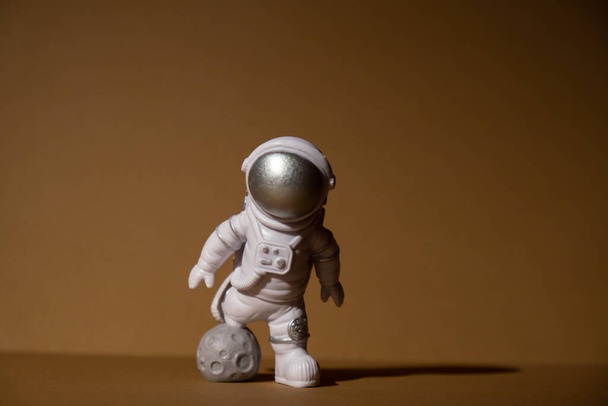 Plastic toy figure astronaut on beige neutral background Copy space. Concept of out of earth travel, private spaceman commercial flights. Space missions and Sustainability - Photo, Image