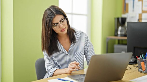 オフィスでノートパソコンを使って仕事をする若い白人女性ビジネスワーカー - 写真・画像