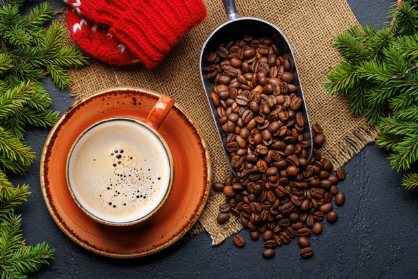 Koffiekopje, gebrande koffiebonen en sparren takken in een gezellige setting. Vlakke lay kerstkaart - Foto, afbeelding