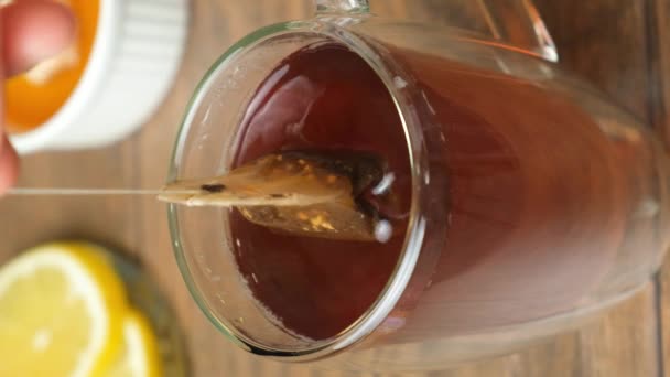 Preparação chá de um saco de chá em uma xícara de vidro - Filmagem, Vídeo