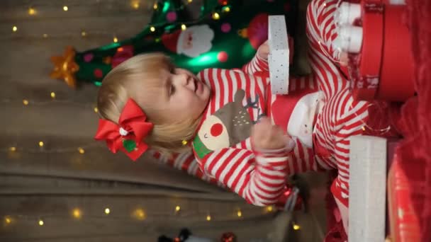 Χαριτωμένο δίχρονο κορίτσι που παίζει με χριστουγεννιάτικα δώρα - Πλάνα, βίντεο