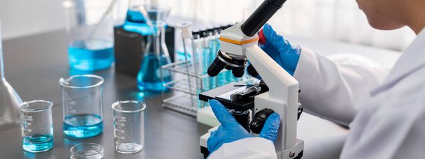 科学者は、新しいワクチン薬や抗生物質を開発するために医療研究室で顕微鏡を使用して化学実験を行います.生物工学研究室と医学研究の概念。顕教 - 写真・画像