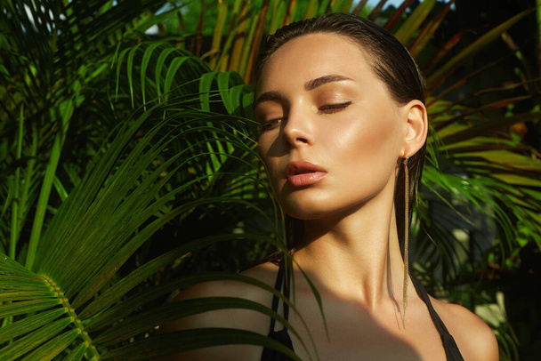 Kaunis kesätyttö märällä hiuksella. nuori seksikäs nainen bikineissä palmun alla. Kauneus muotokuva - Valokuva, kuva