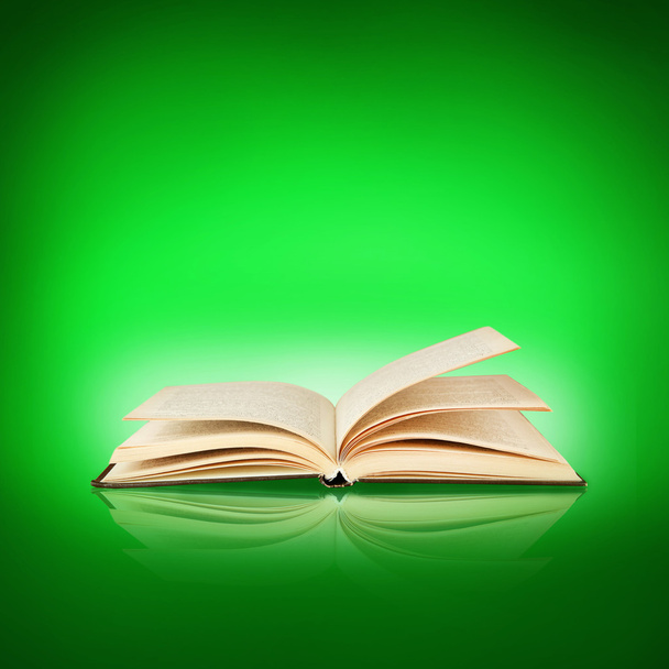 Opende boek op groene achtergrond - Foto, afbeelding