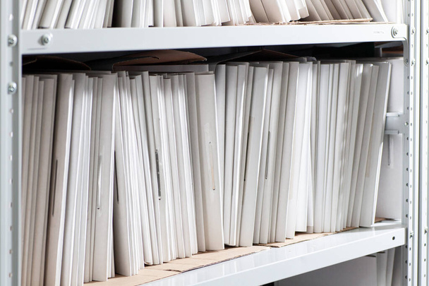 Regale mit Papierdokumenten. Organisierte Büroräume mit übersichtlich geordneten Papierdokumenten und Aktenschränken. - Foto, Bild