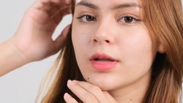 Szépség portré fiatal nő megérinti a sima bőr az arc területén. A bőrápolási smink fogalma. - Felvétel, videó