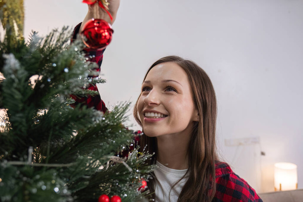 Madre e figlia sono entusiaste e felici di decorare l'albero di Natale a casa durante le vacanze natalizie. Trascorrere del tempo insieme a Natale. - Foto, immagini