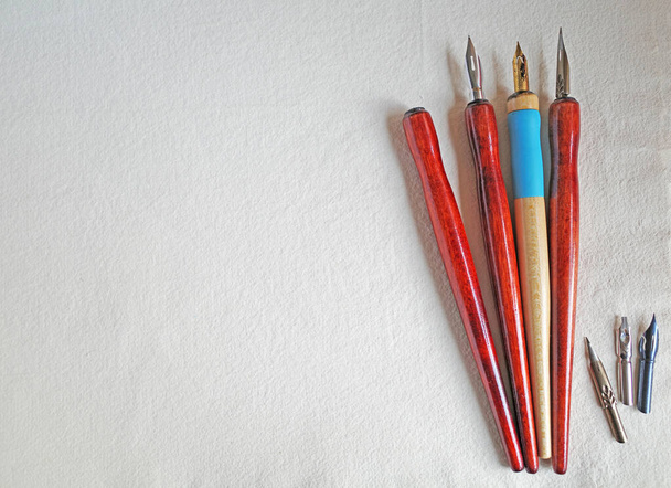 Dip pens with holders lying on handmade paper - Photo, Image