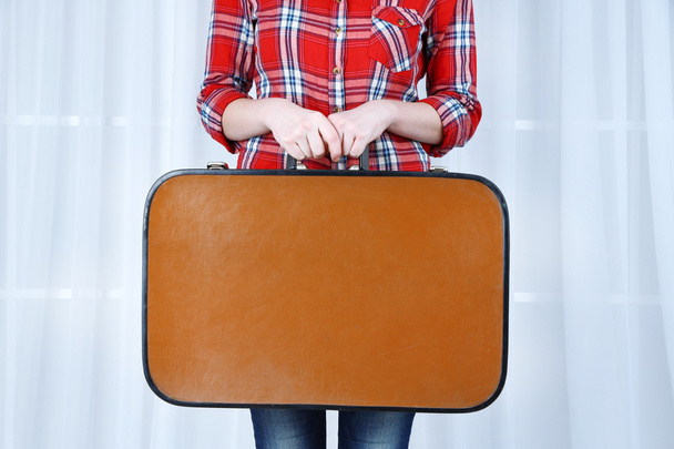 Woman holding old suitcase on fabric background - Foto, Imagen