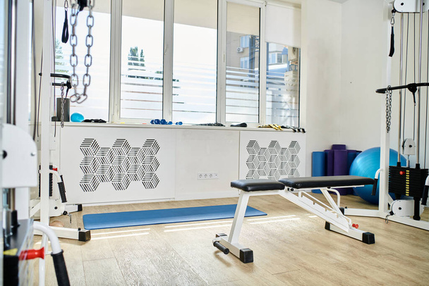 różnorodny sprzęt rehabilitacyjny w przestronnej siłowni ośrodka kinezjologii, nowoczesna medycyna zaawansowana - Zdjęcie, obraz