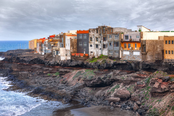 Ряд будинків проникає вздовж краю океанського зсувного узбережжя. Барвисті будинки на узбережжі Гран-Канарії, Канарські острови, Іспанія - Фото, зображення