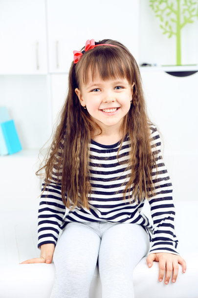 Portrait of cute little girl on home interior background - Zdjęcie, obraz