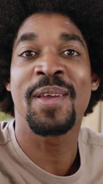 Képernyőkép a fiatal afro-amerikai férfiról, akinek videohívása van okostelefon alkalmazáson. POV vidám, trendi srác csevegett egy barátjával virtuális találkozón, mobiltelefonnal otthonról. Függőleges 9: 16 képernyős videó - Felvétel, videó