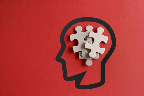 Розсіяні головоломки в голові людини з копіювальним простором на червоному тлі. Аутизм, синдром вниз, стрес і концепція мислення  - Фото, зображення