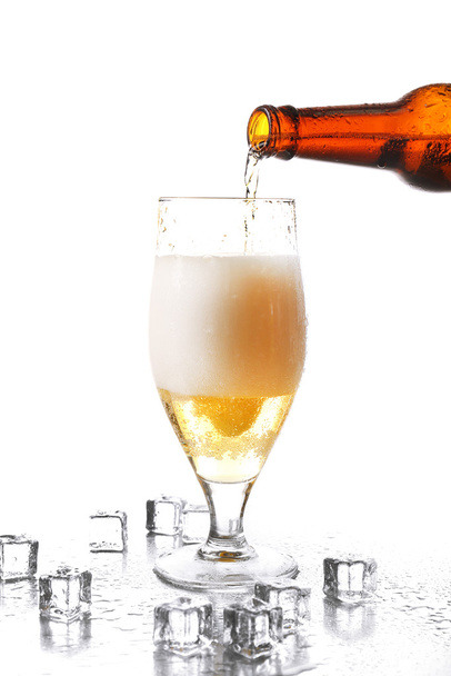 白で隔離ガラス瓶からビールを注ぐ - 写真・画像