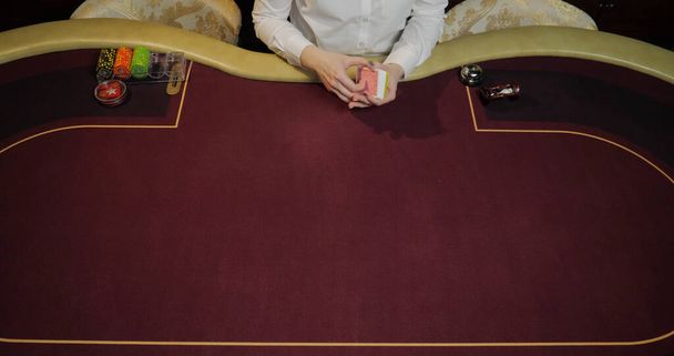 Póker zsetonok és kártyák egy piros asztalon egy kaszinóban. - Fotó, kép