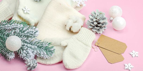 Sıcak kış kompozisyonu. Örgü eldivenler, sıcak eşarp, geleneksel Noel süsü, yeni yıl şenlik havası. Pembe arkaplan, düz yatış, pankart biçimi - Fotoğraf, Görsel