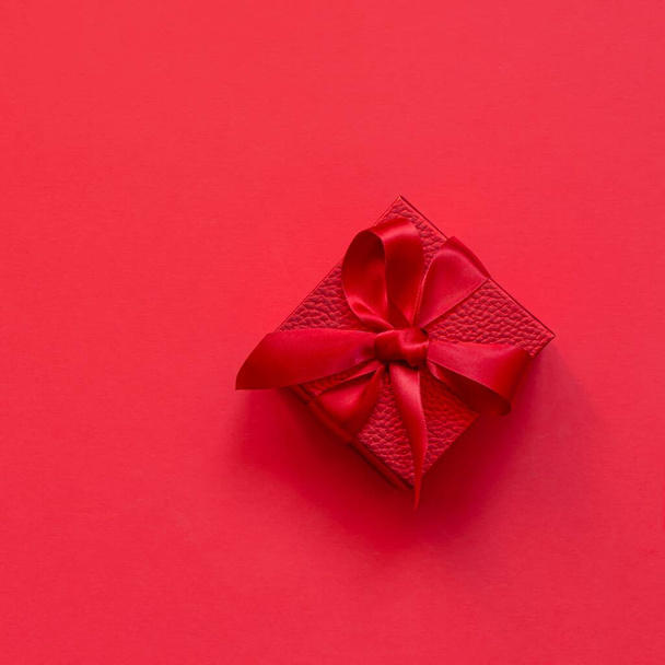 Caja roja (escarlata) (regalo) sobre fondo rojo. Concepto festivo, regalo para cumpleaños, Navidad, San Valentín, Día de las Madres. - Foto, Imagen