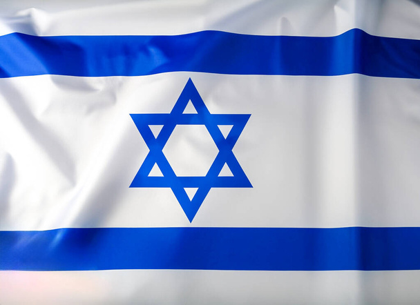 Εθνική σημαία του Ισραήλ κυματίζει στον άνεμο. Ισραηλινή σημαία κυματίζει στον άνεμο. Πρόσθια όψη κλεισίματος. Λευκή και μπλε σημαία με αστέρι του Δαβίδ. - Φωτογραφία, εικόνα