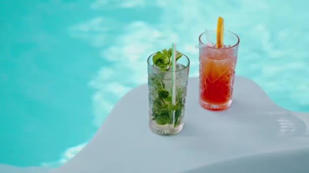 Brýle s alkoholovými koktejly stojící na nároží u bazénu. Bazén s alko nápoji. Přátelé si v létě objednali mojito a aperol. Nové menu barmana. Studené koktejly. Vysoce kvalitní 4K záběry - Záběry, video