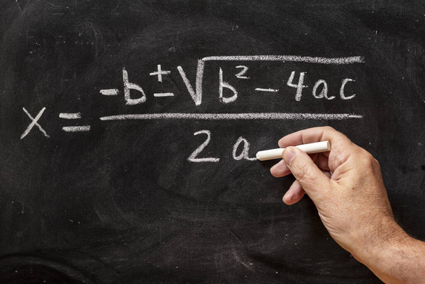 Equazioni quadratiche scritte a mano su lavagna con gesso, formule matematiche - Foto, immagini