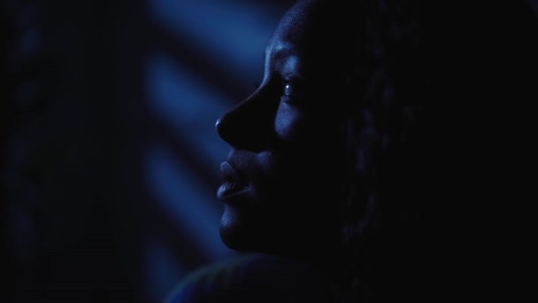 Close-up rosto jovem mulher negra americana sente solidão e depressão sozinho no quarto em casa no escuro, feminino triste pensativo. A menina tem problemas mentais e insônia. Conceito de ansiedade na solidão.  - Filmagem, Vídeo