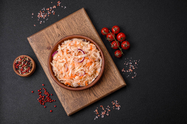 Köstlich eingelegtes, gesalzenes Kraut mit Karotten, Salz und Gewürzen in einem Keramikteller - Foto, Bild