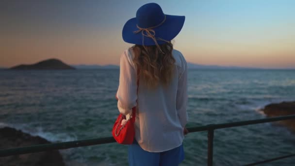 Туристична жінка в блакитному капелюсі біля моря. - Кадри, відео