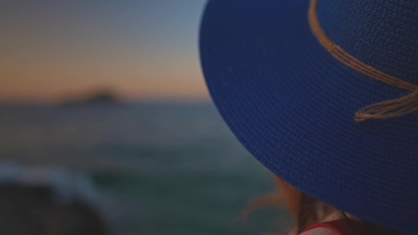 Τουριστική γυναίκα με μπλε καπέλο δίπλα στη θάλασσα. - Πλάνα, βίντεο