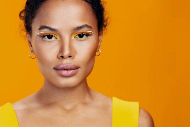 スマイル女性スタイルのアフリカの化粧品のスキン美容スペースファッションコピーブラックモデルメイクアップ美しいピンクの創造的な化粧品顔の肖像画黄色のカラフルなスタジオ - 写真・画像
